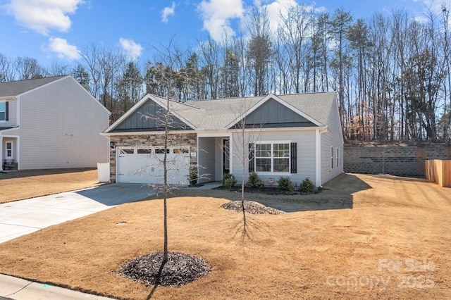 view of front of house featuring a garage, a shingled roof, concrete driveway, fence, and board and batten siding