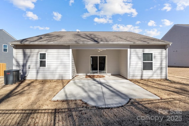 back of house with ceiling fan, central AC unit, roof with shingles, and a patio area