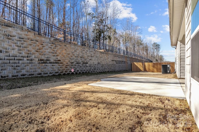 view of yard with a fenced backyard, a patio, and central air condition unit