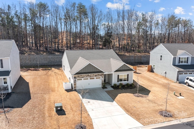 view of front facade with driveway, board and batten siding, an attached garage, and roof with shingles