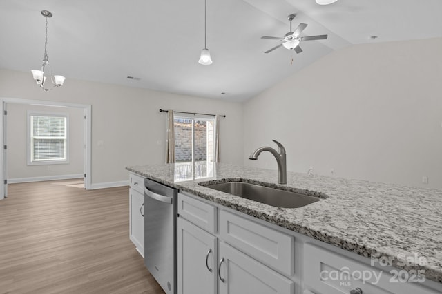 kitchen with dishwasher, light stone counters, a sink, and white cabinets