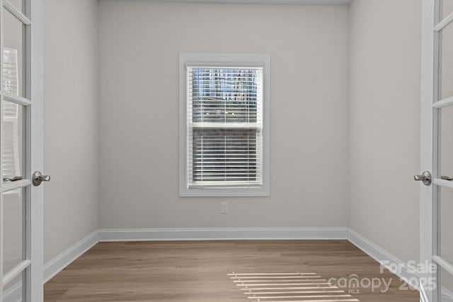 empty room featuring light wood-style flooring and baseboards