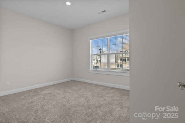 unfurnished room with light carpet, visible vents, and baseboards