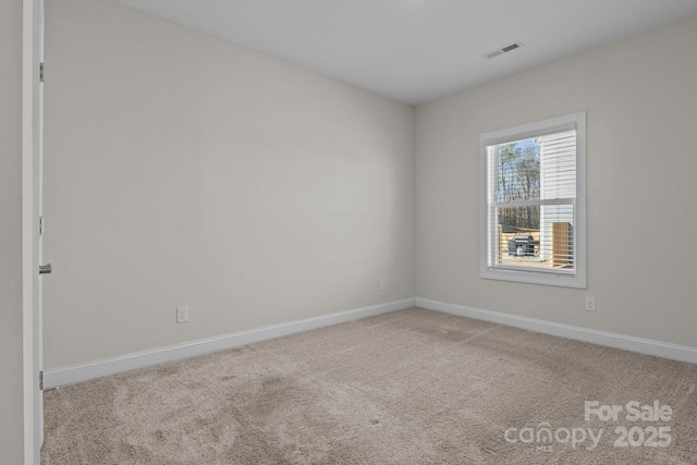 empty room featuring light carpet, visible vents, and baseboards