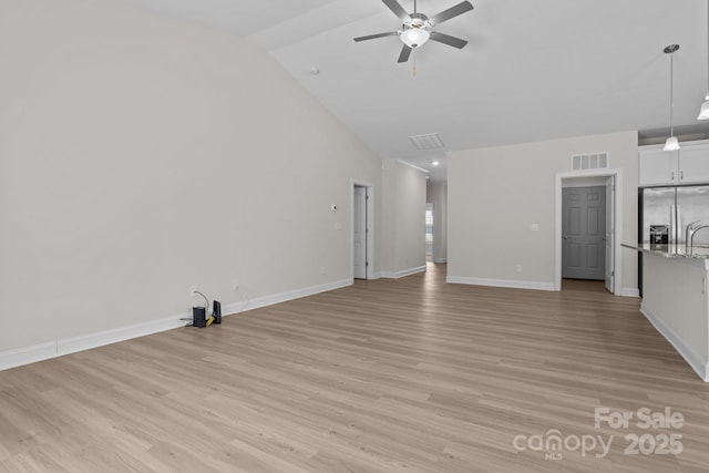 unfurnished living room with ceiling fan, visible vents, lofted ceiling, and light wood finished floors