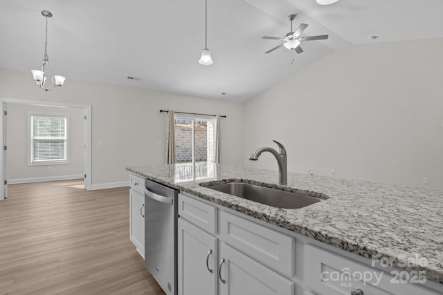 kitchen featuring a sink, stainless steel dishwasher, white cabinetry, and decorative light fixtures