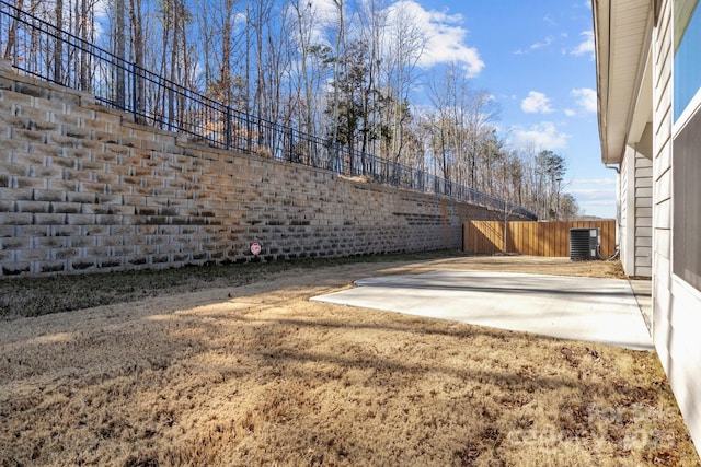 view of yard with fence, a patio area, and central AC