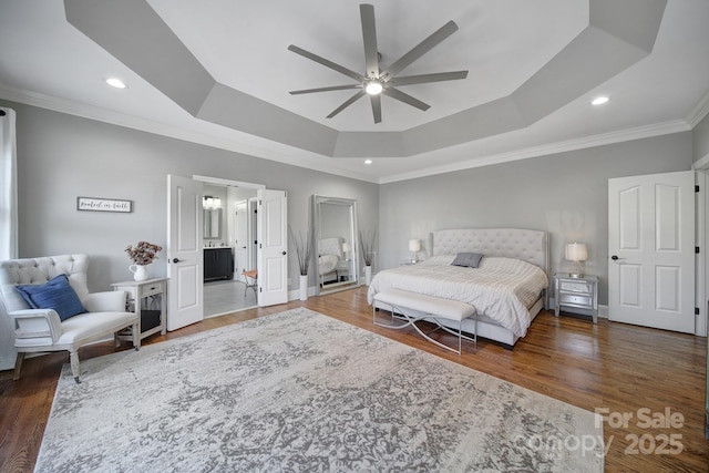 bedroom with wood finished floors, baseboards, a tray ceiling, recessed lighting, and ornamental molding