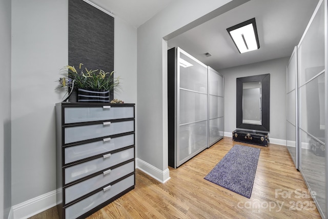 foyer with baseboards and light wood-type flooring