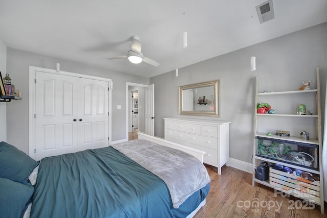 bedroom featuring visible vents, baseboards, light wood-type flooring, a closet, and a ceiling fan