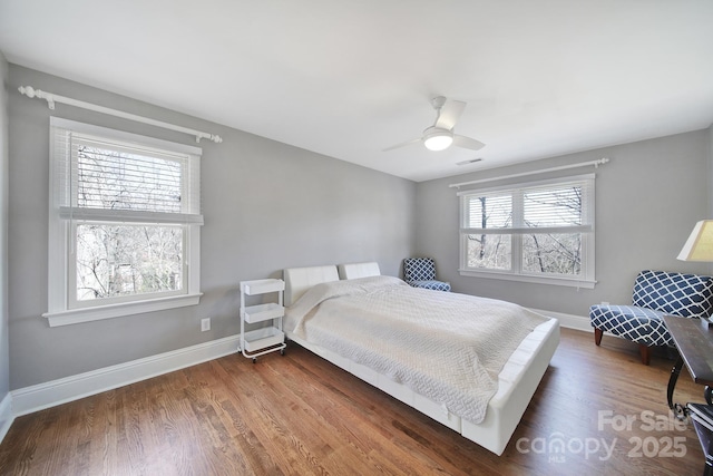 bedroom featuring a ceiling fan, baseboards, and wood finished floors