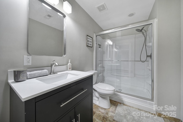 bathroom with visible vents, toilet, a stall shower, and vanity