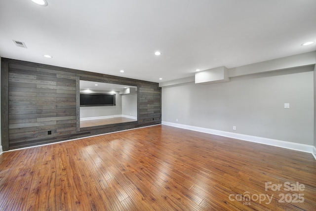 unfurnished living room with recessed lighting, baseboards, wood-type flooring, and visible vents