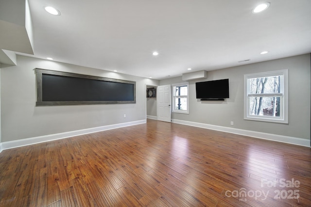 unfurnished living room with dark wood finished floors, visible vents, recessed lighting, and baseboards