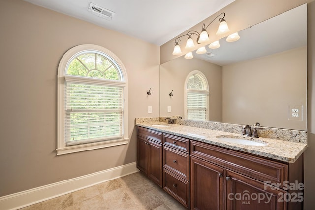 full bathroom featuring visible vents, a sink, baseboards, and double vanity