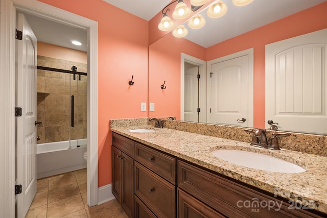 bathroom with double vanity, shower / bath combination with glass door, a sink, and toilet