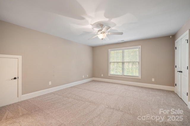 empty room with light carpet, ceiling fan, visible vents, and baseboards