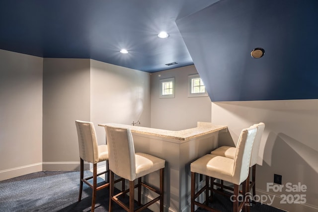 interior space featuring recessed lighting, visible vents, dark carpet, a bar, and baseboards