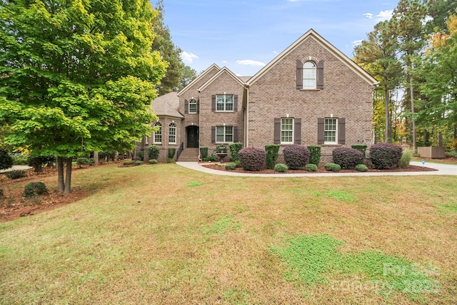 traditional-style house featuring brick siding and a front yard