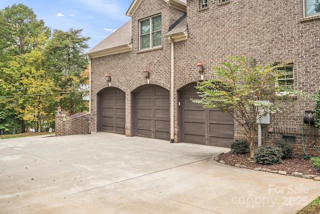 view of home's exterior featuring a garage, driveway, and brick siding