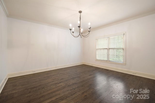 spare room featuring ornamental molding, dark wood finished floors, baseboards, and an inviting chandelier