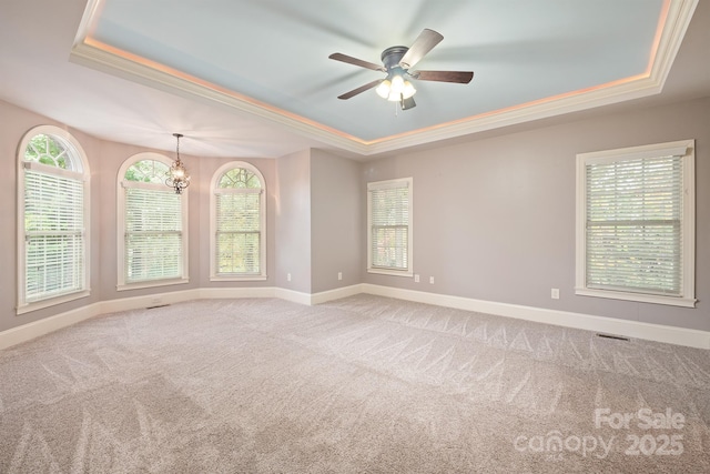 spare room with baseboards, a raised ceiling, and light colored carpet