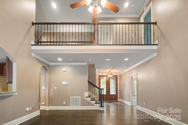 foyer with baseboards, visible vents, dark wood-type flooring, and ornamental molding