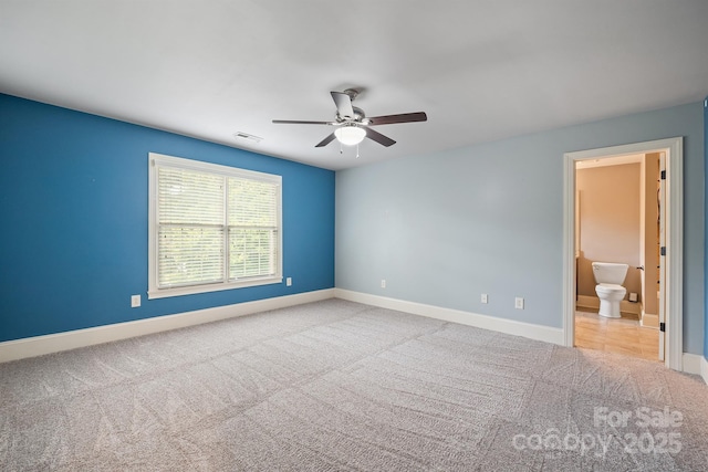 empty room with light carpet, visible vents, a ceiling fan, and baseboards