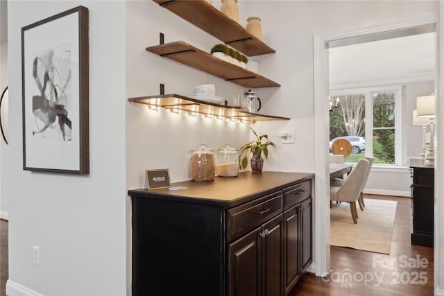 bar featuring dark wood-style floors and baseboards