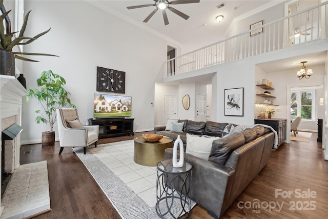 living area with light wood-type flooring, baseboards, visible vents, and a fireplace with raised hearth