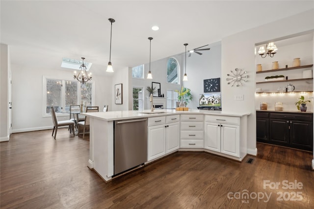 kitchen with light countertops, dark wood-type flooring, white cabinets, a chandelier, and dishwasher