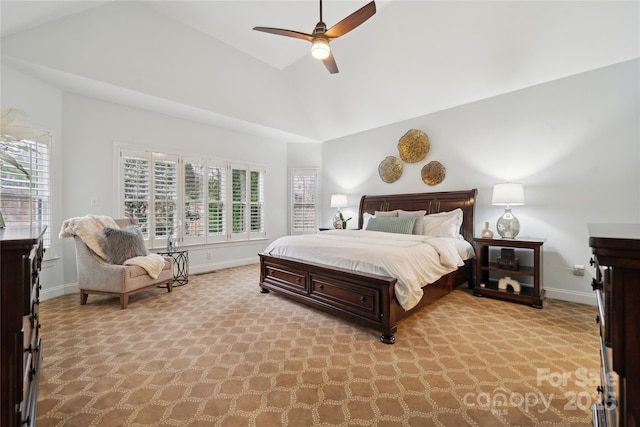 bedroom with light carpet, ceiling fan, baseboards, and vaulted ceiling