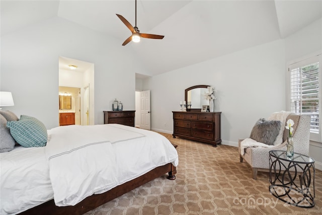 bedroom with baseboards, connected bathroom, light colored carpet, ceiling fan, and high vaulted ceiling