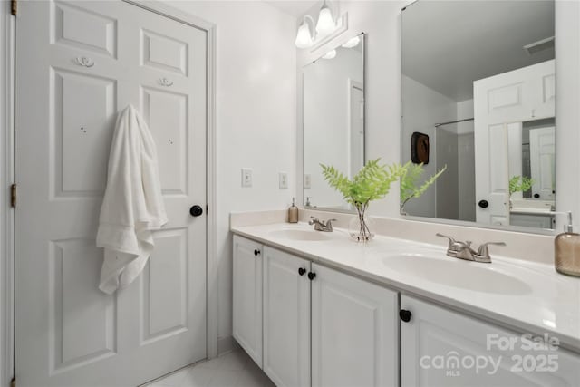 full bath with double vanity, visible vents, a sink, and tile patterned floors