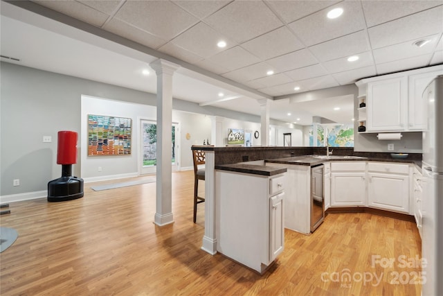 kitchen with open shelves, dark countertops, and white cabinetry