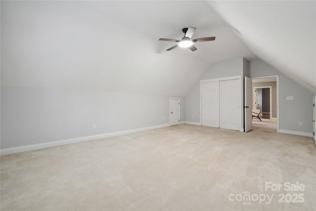 bonus room featuring light carpet, lofted ceiling, a ceiling fan, and baseboards