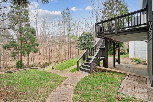 view of yard with a deck, a patio, and stairway