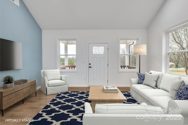 living room with lofted ceiling, light wood-style floors, visible vents, and baseboards