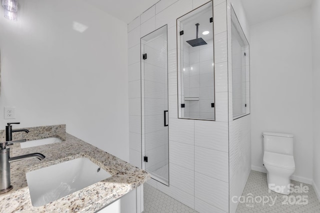 bathroom featuring a stall shower, a sink, toilet, and double vanity