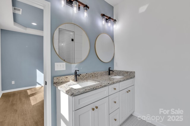 full bath with a sink, baseboards, and double vanity