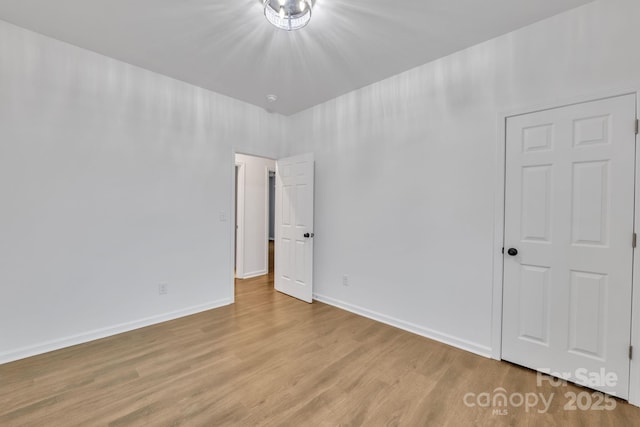 empty room with baseboards and light wood finished floors