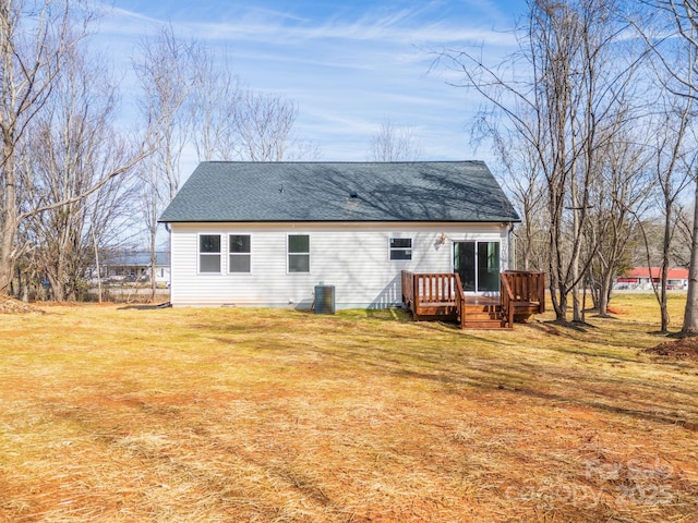 back of property with a yard, a shingled roof, central AC, and a wooden deck