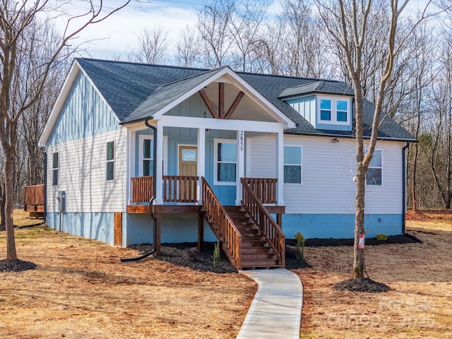 view of front of home with a porch, board and batten siding, and roof with shingles