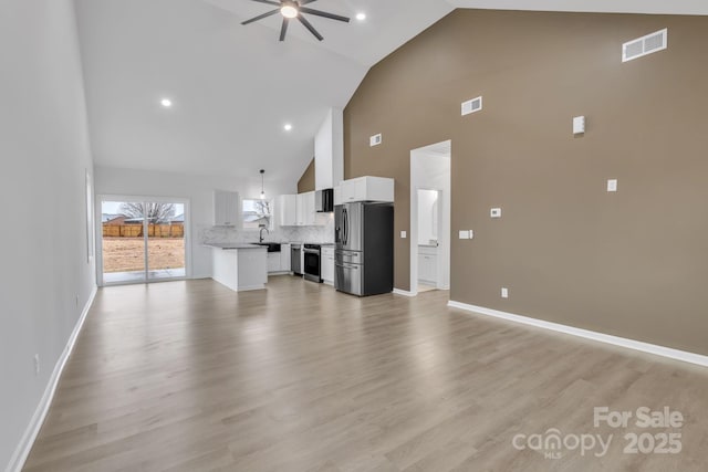 unfurnished living room featuring a ceiling fan, light wood-style flooring, visible vents, and baseboards