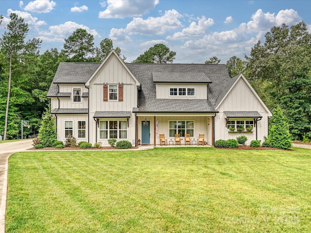 modern inspired farmhouse featuring covered porch and a front yard