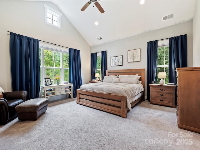 carpeted bedroom with ceiling fan and high vaulted ceiling