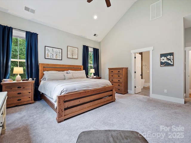 carpeted bedroom with multiple windows, high vaulted ceiling, ceiling fan, and ensuite bathroom