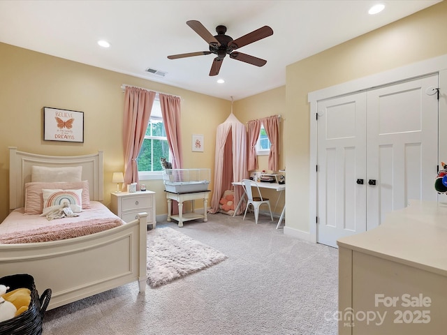 carpeted bedroom with ceiling fan and a closet