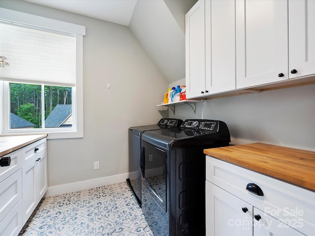 laundry area with light tile patterned flooring, cabinets, and washing machine and dryer