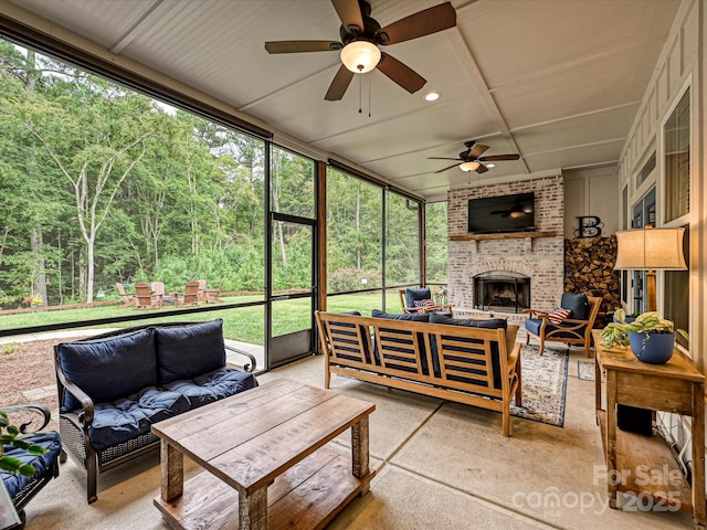 sunroom / solarium with ceiling fan and a fireplace